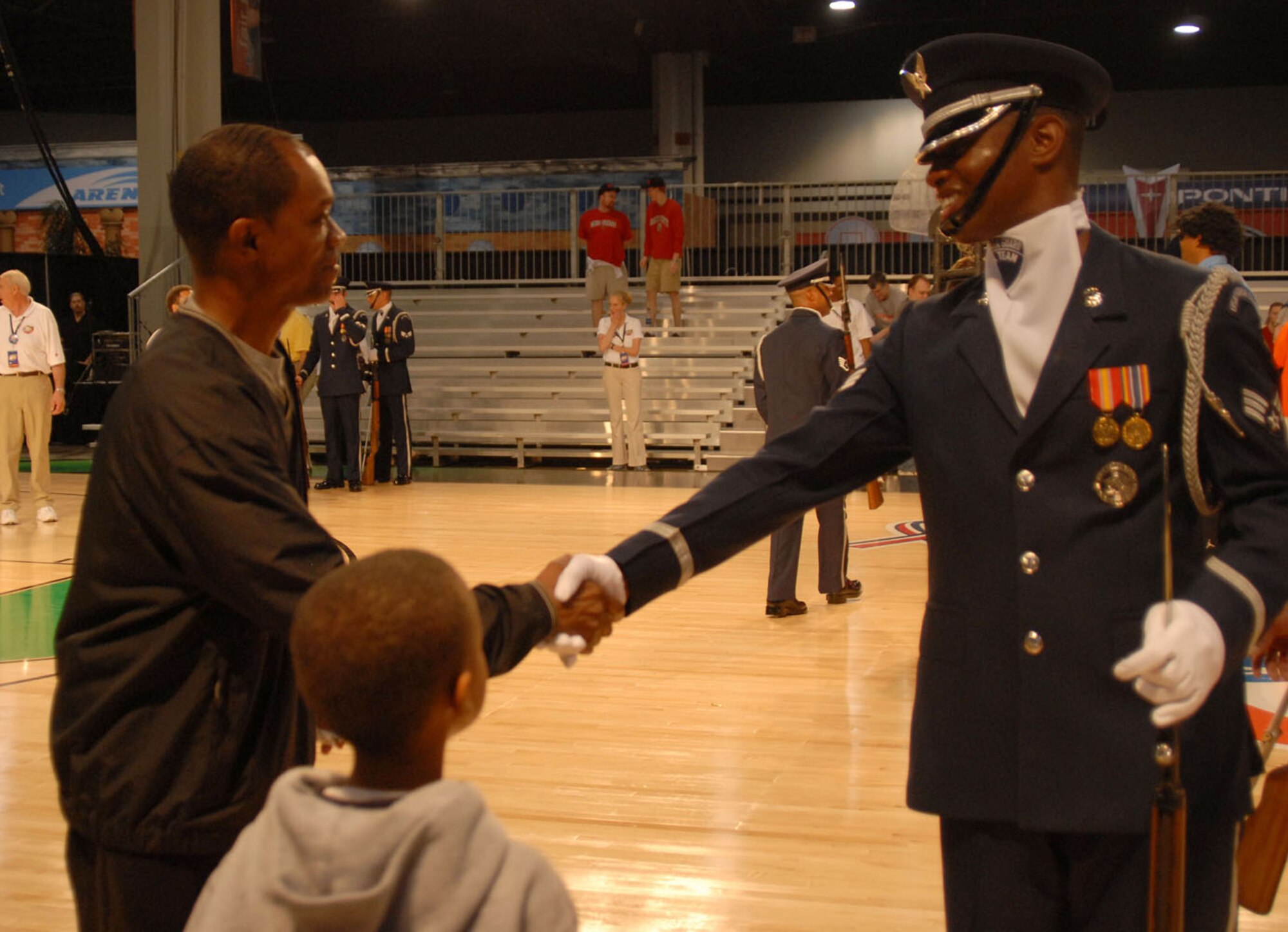 ATLANTA, Ga -- Senior Airman Michael Jiggets, United States Air Force Honor Guard Drill Team member, speaks with basketball fans after the team's performance at Hoop City for the NCAA Final Four Tournament.  The Air Force Honor Guard Drill Team was invited to perform for various ceremonies associated with the NCAA Final Four events March 31 - April 2, including the opening ceremonies at Centennial Olympic Park March 31.