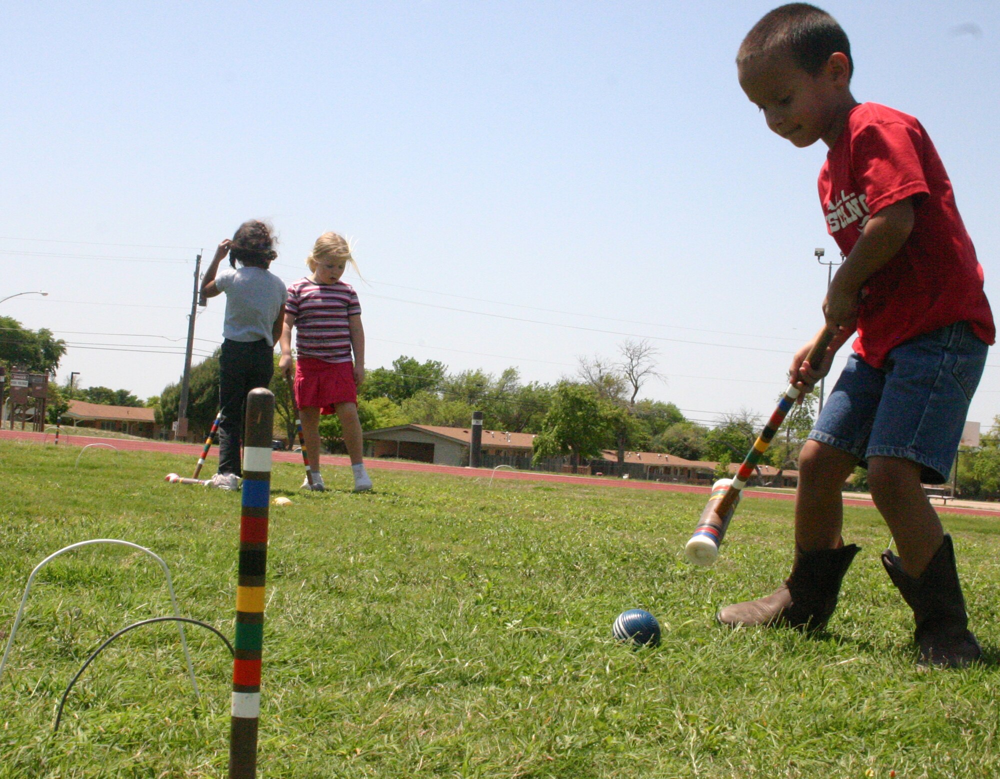 LAUGHLIN AIR FORCE BASE, Texas -- Joshua Jackey, son of Yolanda  and David Jackey, Lear Siegler Incorporated, has fun with physical education as he learns to play croquet with fellow classmates with Texas Hope, a home school group, on the base football field April 12, 2007. 