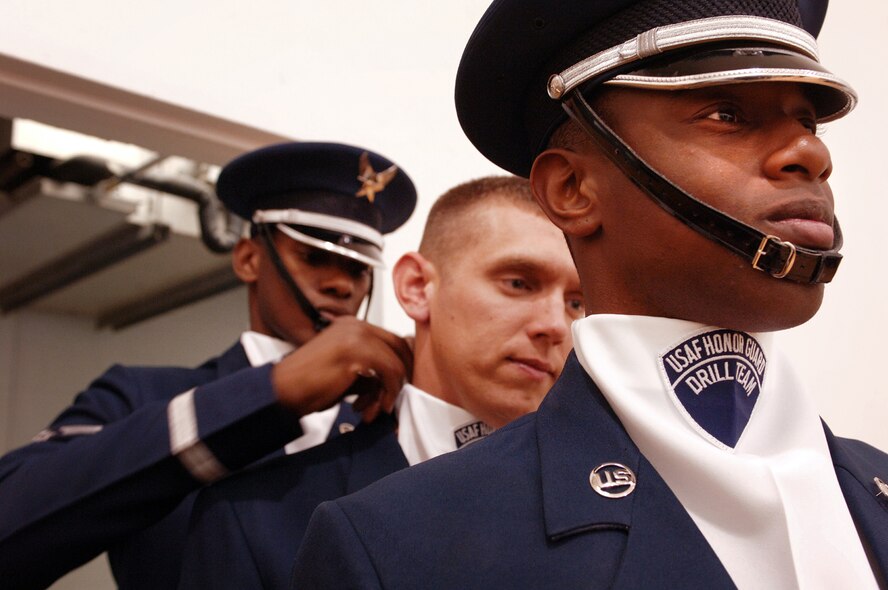 Senior Airman Jermaine James, Senior Airman James Floyd and Senior Airman Michael Jiggets adjust each others uniorms prior to their drill team performance at the Hess Fitness Center. The three airmen are members of the Honor Guard Drill Team from Bolling Air Force Base, Washington, D.C., who were TDY to Hill AFB to showcase their rifle drill performance.