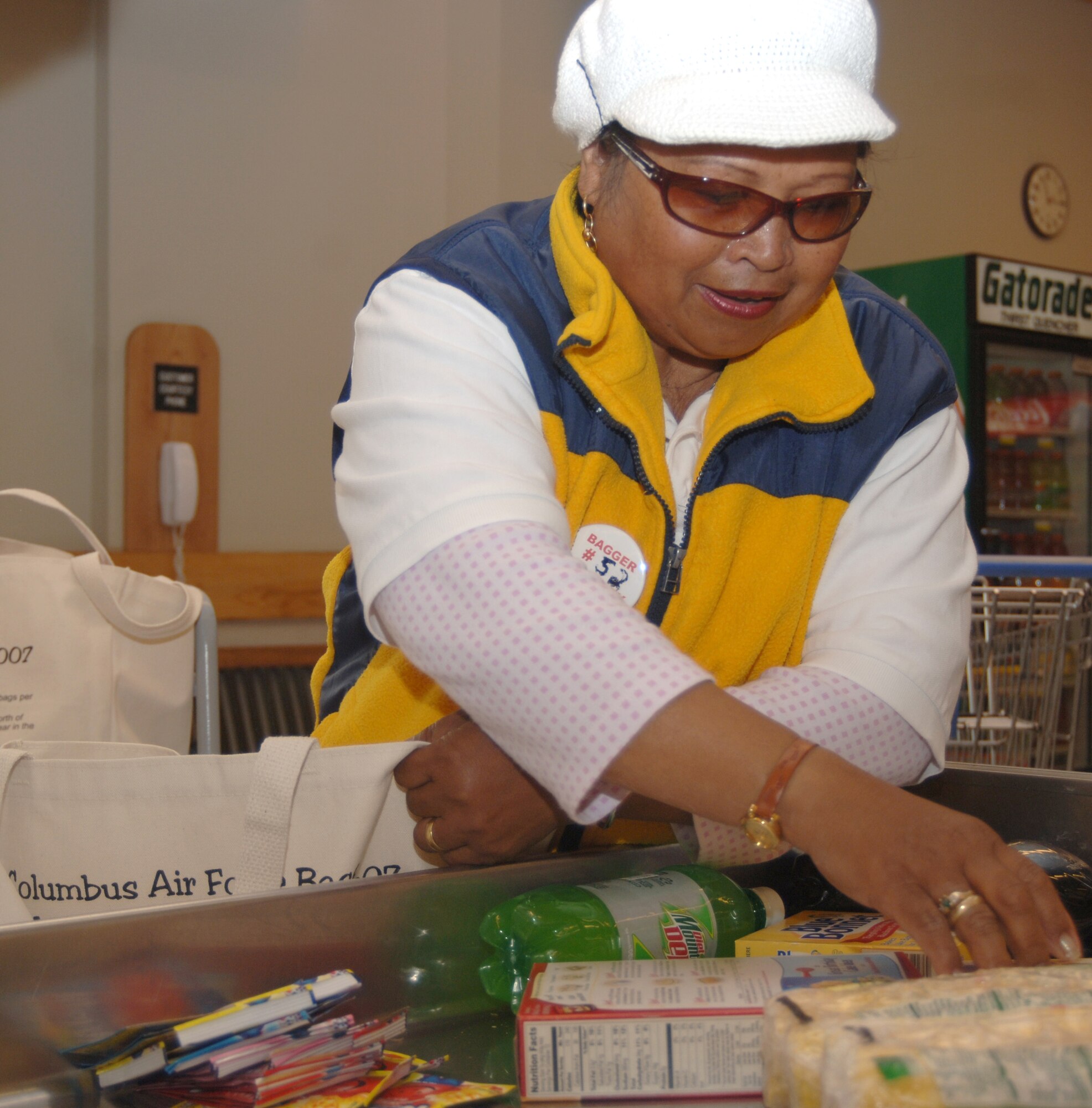 Tina Hilberg packs a customer’s grocery items in reusable cloth bags. The Columbus Air Force Base Commissary handed out 500 environmentally-friendly bags as part of their Earth Day celebration. The bags were donated by the base recycling center. (Photo by Senior Airman John Parie)