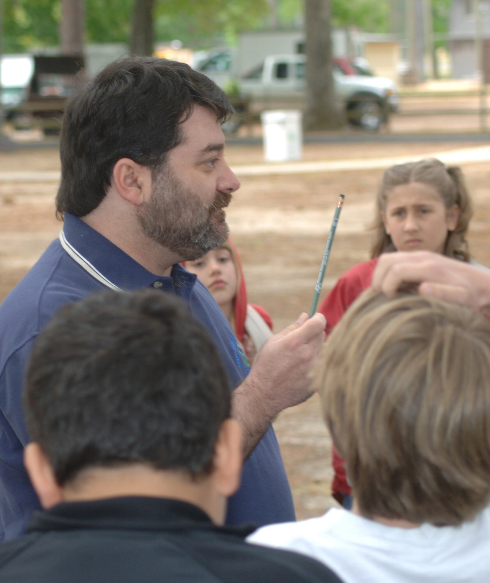 John David Burns, left, from the Mississippi Department of Environmental Quality recycling division, shows fourth graders from New Hope Elementary School a pencil made from recycled U.S. currency, as well as other pencils made from blue jeans and cardboard boxes. Students from Lowndes County Schools visited Columbus Air Force Base April 13 as part of an annual Earth Day celebration. (Photo by Senior Airman John Parie)