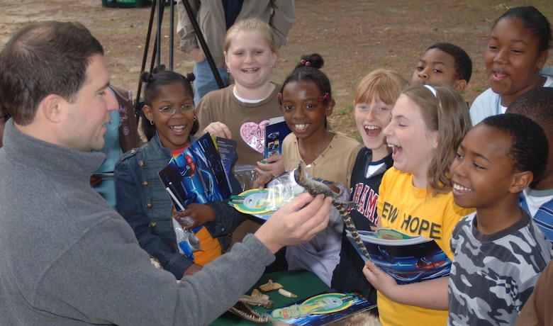 John DeFillipo, left, from the Mississippi Museum of Natural Science, shows fourth graders from New Hope Elementary School a baby alligator, which lives natively in Mississippi. Students from Lowndes County Schools visited Columbus Air Force Base April 13 as part of an annual Earth Day celebration. (Photo by Senior Airman John Parie)