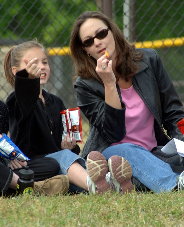Kim White, right, and Cheyenne Rhodes, from New Hope Elementary School, take a break from the numerous activity centers to enjoy the Spring day and watch as various Columbus Air Force Base training aircraft fly overhead. Fourth graders from Lowndes County Schools visited Columbus Air Force Base April 13 as part of an annual Earth Day celebration. (Photo by Senior Airman John Parie)
