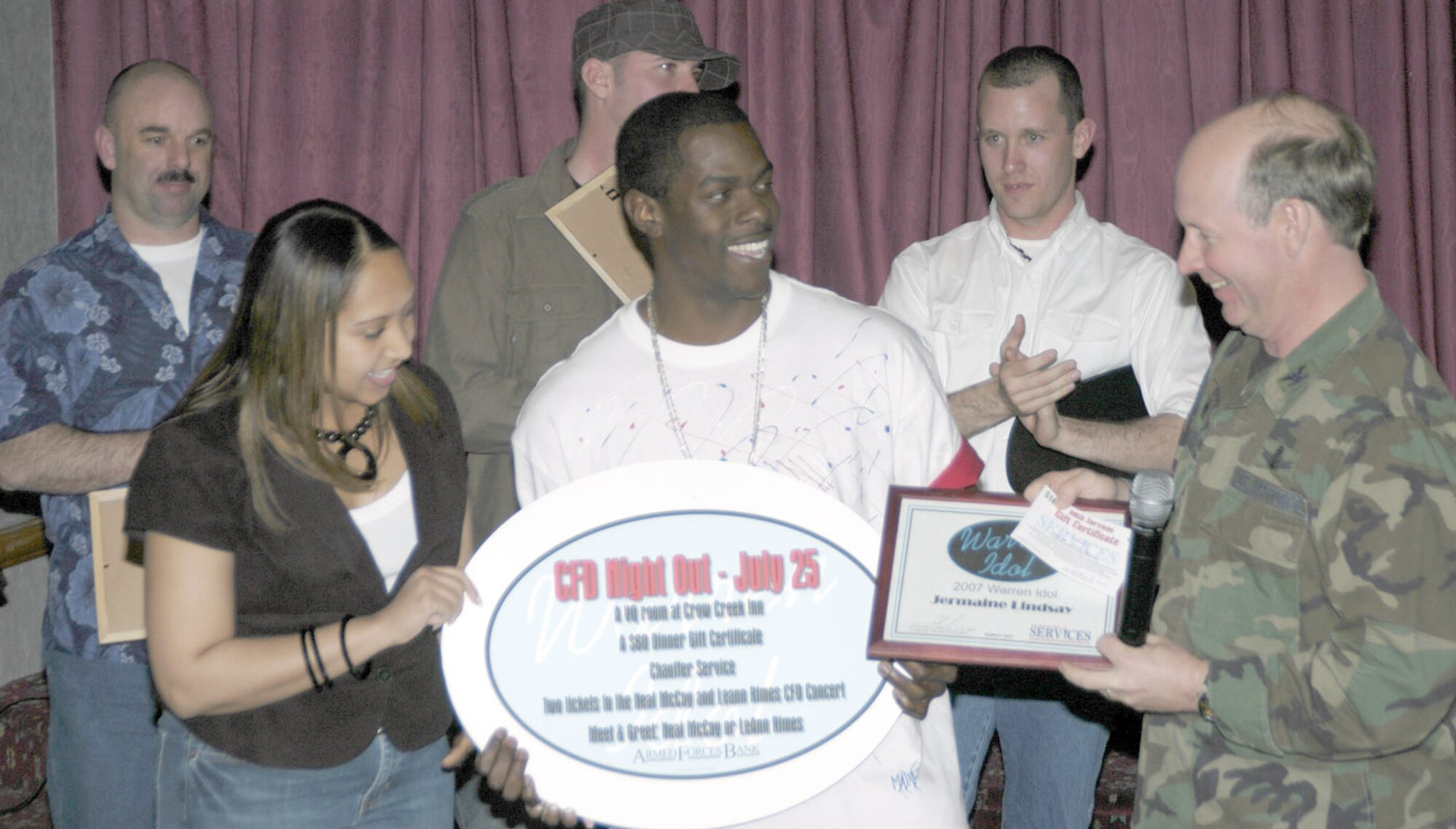 Airman Lindsay receives a Cheyenne Frontier Days night out and certificate from Col. Ron Jenkins, 90th Mission Support Group commander, after he was announced the winner of the 4-week singing competition.