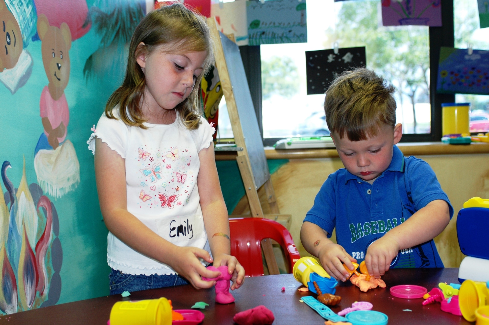 Emily Franzer, age 5, along with her brother Ian, age 2, children of Master Sgt. Scott and Andrea Franzer, 60th Operations Group, make different shapes out of Play-Doh® during their stay at the Teddy Watch program at the David Grant USAF Medical Center, Wednesday. (U.S. Air Force photo by Tech. Sgt. Donald Osborn)