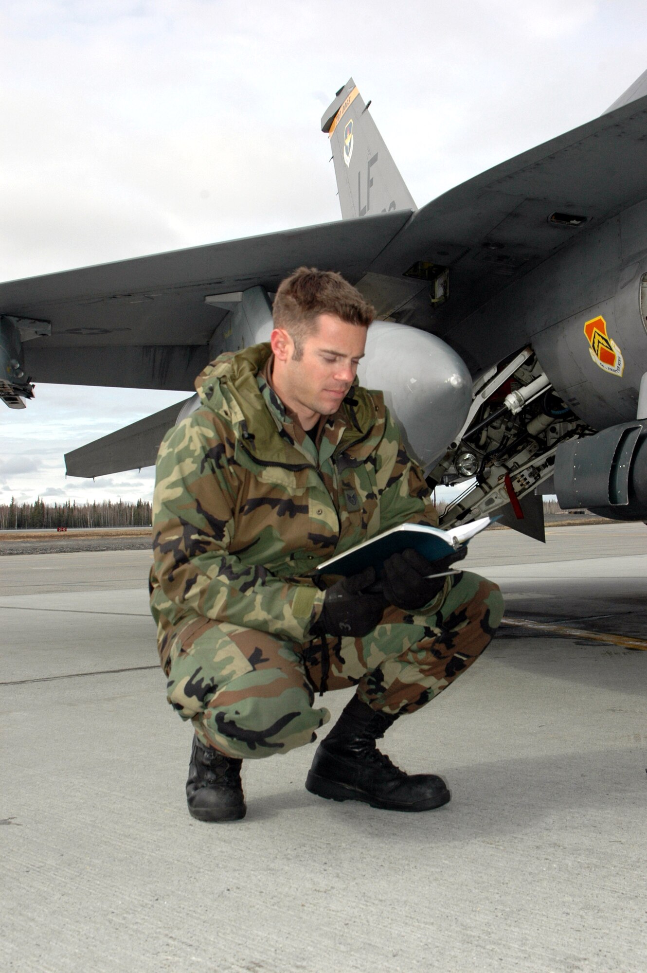 Staff Sgt. Craig Bair reads a checklist before performing maintenance on an F-16 Fighting Falcon April 11 during Red Flag-Alaska 07-1 on the flightline at Eielson Air Force Base, Alaska. Red Flag-Alaska is a Pacific Air Forces-directed field training exercise flown under simulated air combat conditions. It is conducted on the Pacific Alaskan Range Complex with air operations flown out of Eielson and Elmendorf Air Force bases. Sergeant Bair is a 61st Fighter Squadron crew chief. (U.S. Air Force photo/Tech. Sgt. William Farrow)