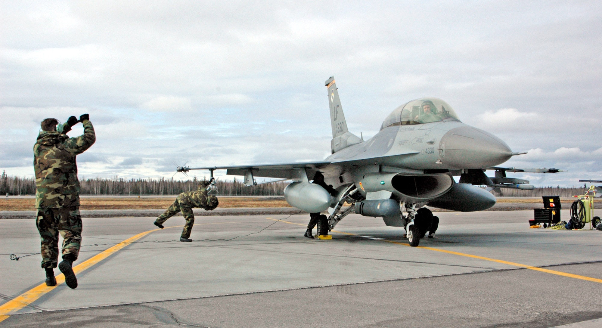 Airmen from the 61st Fighter Squadron catch an F-16 Fighting Falcon on the flightline during Red Flag-Alaska 07-1 April 11 at Eielson Air Force Base, Alaska. Red Flag-Alaska is a Pacific Air Forces-directed field training exercise flown under simulated air combat conditions. It is conducted on the Pacific Alaskan Range Complex with air operations flown out of Eielson and Elmendorf Air Force bases.(U.S. Air Force photo/Tech. Sgt. William Farrow)
