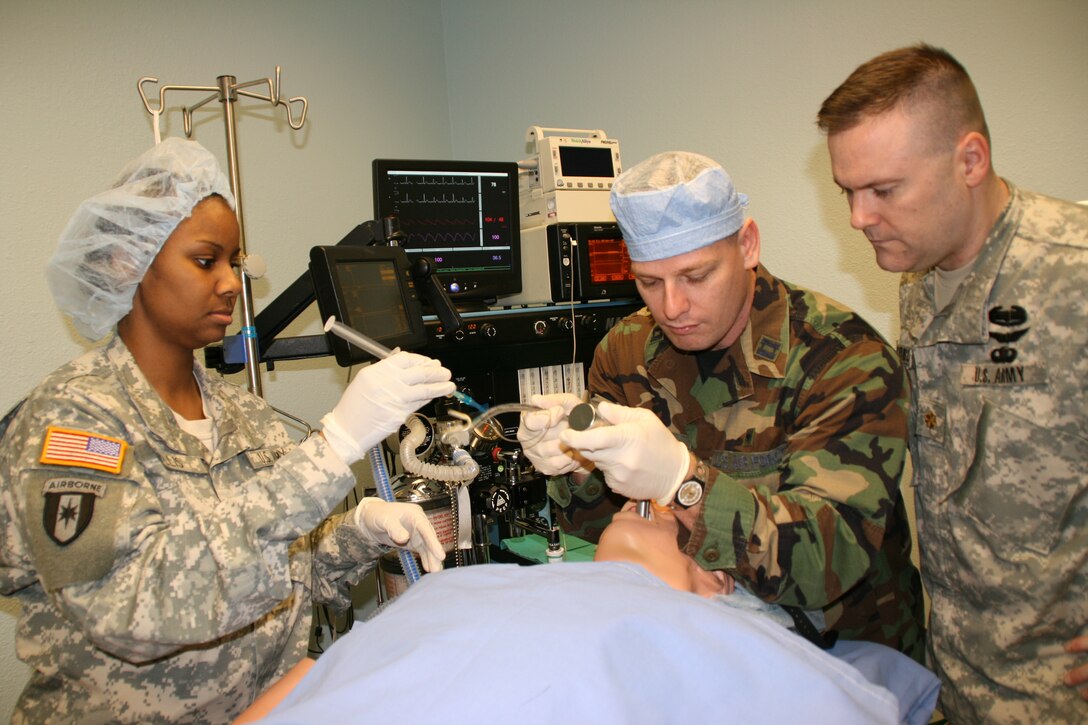 From left: Army Capt. Thurayya Gillis and Air Force Capt. Daniel Moore practice intubation on a human patient simulator while Maj. Jeffrey Conroy, director of the simulation program, provides instruction April 6 at the Army Medical Department Center and School, at Fort Sam Houston, Texas. U.S. Army photo by Elaine Wilson