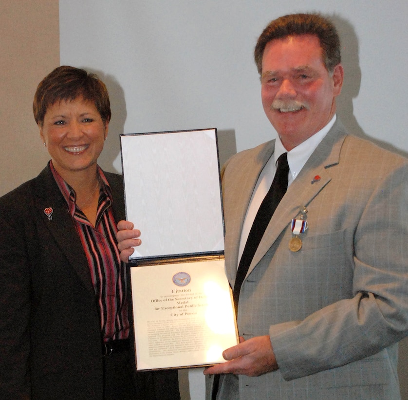 Mayor Bob Barrett of Peoria, Ariz., right, accepts the Office of the Secretary of Defense Exceptional Public Service Award from Allison Barber, deputy assistant secretary of defense for public liaison and internal communications, April 12. The city received the award for its support of servicemembers. Defense Dept. photo by Samantha L. Quigley