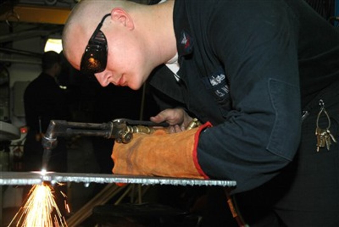 U.S. Navy Petty Officer 2nd Class Cory West, cuts a steel plate to make an electrical mounting bracket aboard USS Bonhomme Richard, April 12, 2007. The Bonhomme Richard Expeditionary Strike Group is under way for a scheduled deployment. 
