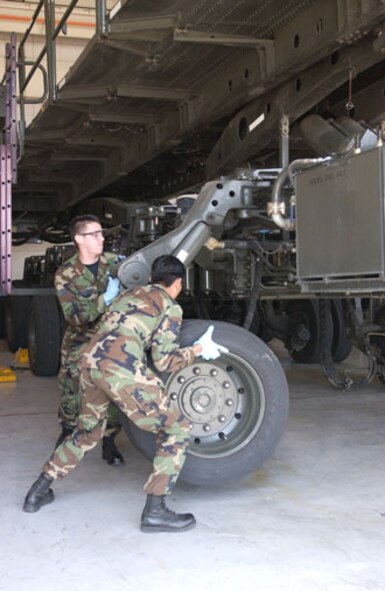 Senior Airman Jaime Hinojosa-Guzman, 452nd Logistics Readiness Squadron, March Air Reserve Base, Calif., disconnects the axle bolts in preparation for air transport. (U.S. Air Force photo by Staff Sgt. Amy Abbott)