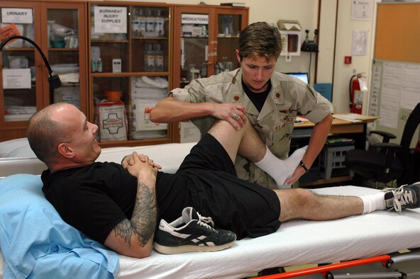 Dr. (Maj.) Colleen Christensen, 379th Expeditionary Medical Group orthopedic surgeon and chief of hospital services, works with Army Sgt. Michael Millman, 182 Attack Reconnaissance Battalion, at the 379th EMDG Monday. Through its In-Theater Care Program, the medical staff treats servicemembers who have been evacuated from forward operating locations and U.S. Navy ships operating in the Central Command area of responsibility. (U.S. Air Force photo by Senior Airman Erik Hofmeyer)