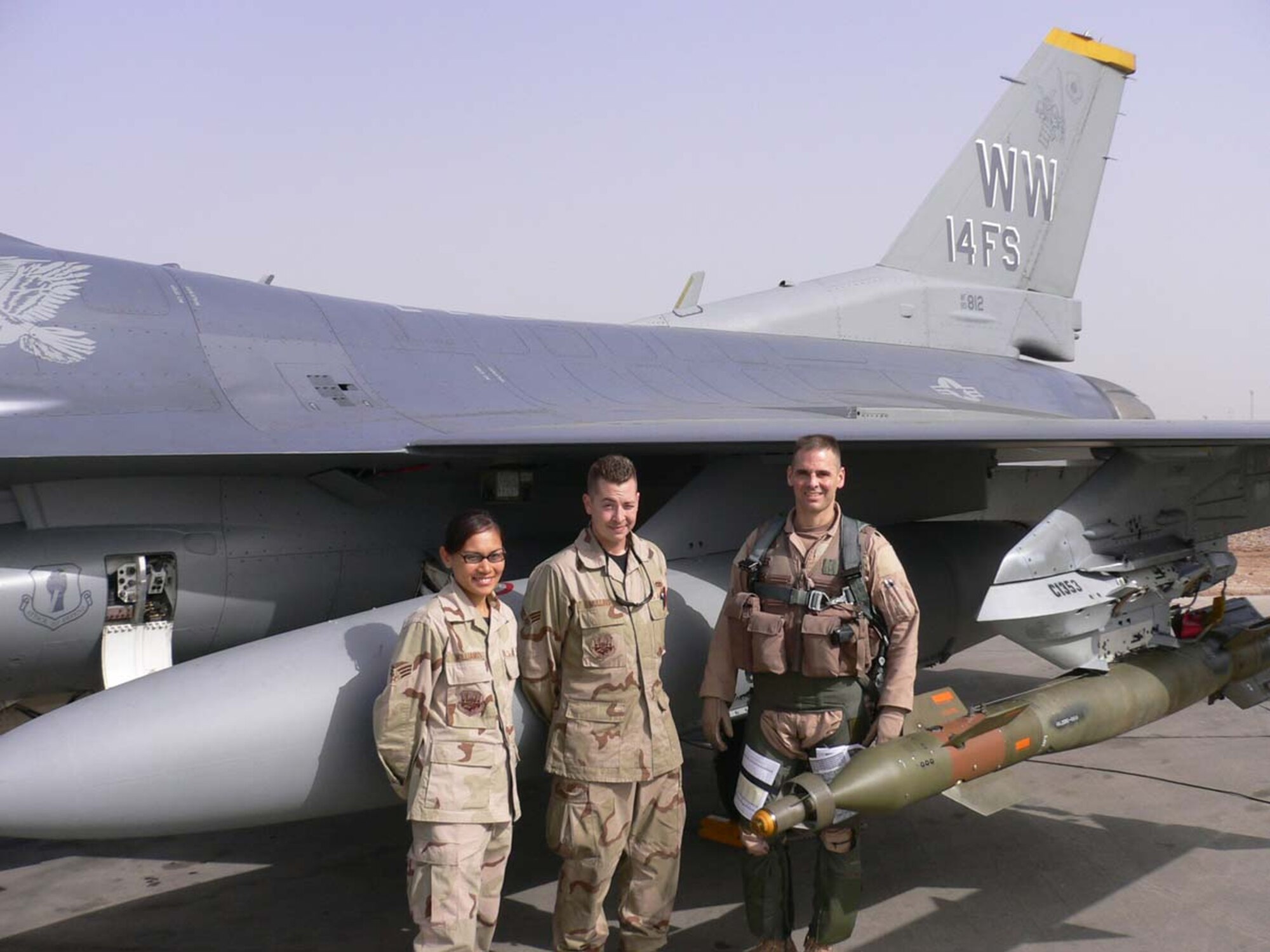 070412--BALAD AIR BASE, Iraq -- Senior Airman Rosanne Williams and Senior Airman Benjamin Mullins, 332nd Expeditioanry Aircraft Maintenance Squadron weapon loaders, pose with Lt. Col. Charles Topilkar, 14th Expeditioanry Fighter Squadron commander, on the flightline at Balad. (Courtesy photo)