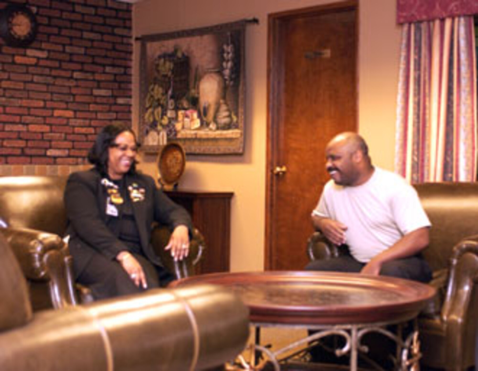 Jacqueline MacGowan, front desk manager for the March Inn, and Henry Frye, club operations assistant, enjoy the plush chairs in the new business lounge at March Air Reserve Base. (U.S. Air Force photo by Staff Sgt Amy Abbott, 452 AMW/PA)