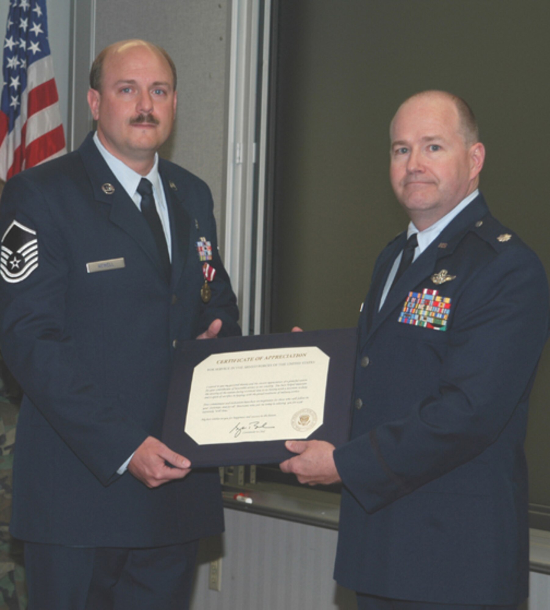 GRISSOM AIR RESERVE BASE, Ind -- Air Force Reserve Master Sgt. Timothy A. Newell of Logansport, Ind., (left) accepts a retirement certificate from Lt. Col. Dan Harrison, 434th Mission Support Group commander, during a retirement ceremony held April 14.  Sergeant Newell retired after 20 years of service to his country. (U.S. Air Force photo/Lt. Col. Gary Lockard)