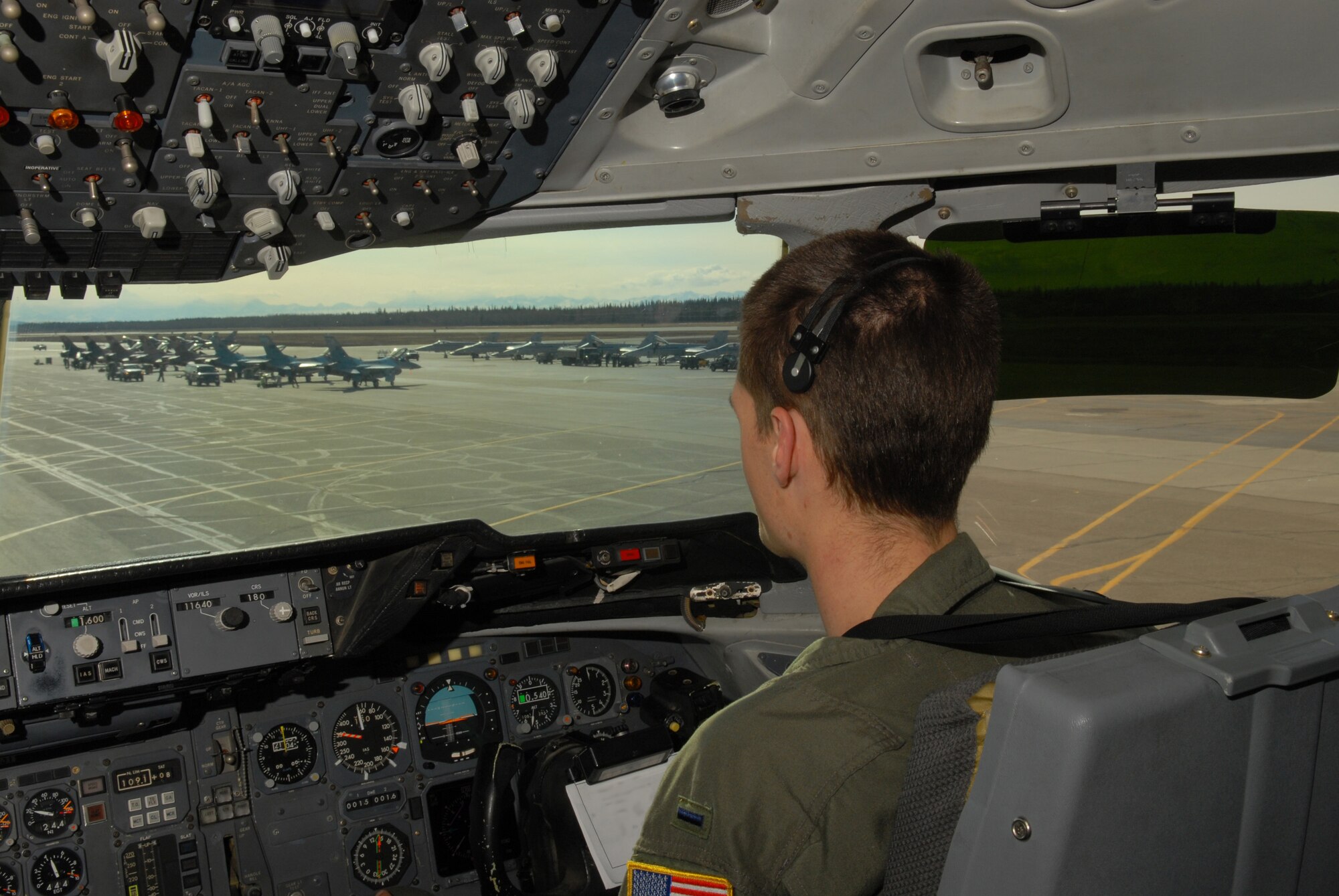 EIELSON AIR FORCE BASE, Alaska -- 1st  Lt. Ryan Maclean, 6th Air Refueling Squadron, Travis AFB, C.A., looks at the F-16 Aggressors while taxiing a KC-10 Extender on the flightline on April 16 during Red Flag-Alaska 07-1. Red Flag-Alaska is a Pacific Air Forces-directed field training exercise for U.S. forces flown under simulated air combat conditions. It is conducted on the Pacific Alaskan Range Complex with air operations flown out of Eielson and Elmendorf Air Force Bases. (U.S. Air Force Photo by Airman 1st Class Jonathan Snyder)