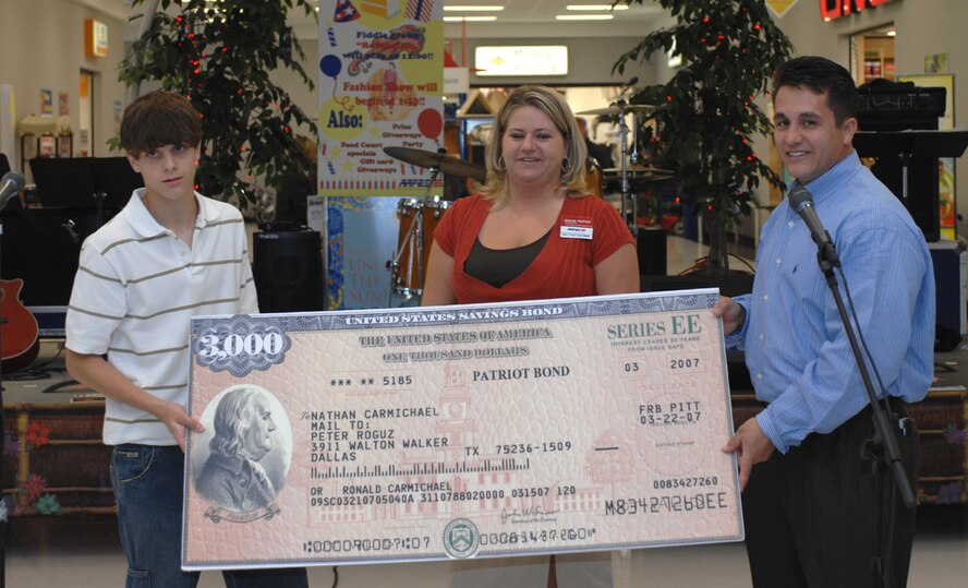 Ron Barfield, Dyess' Base Exchange general manager (right), and Amanda Hartfield, assistant store manager (center), present Nathan Carmichael (left) a $3,000 savings bond April 14 for his selection as second-place winner for the Army and Air Force Exchange Service's "You Made the Grade" contest, 4th quarter, 2006. The contest is Air Force-wide, and Nathan was one of only three applicants to receive an award during that quarter. (U.S. Air Force photo by Amn Jennifer Romig)