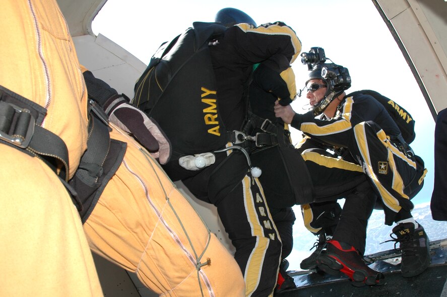 OVER EGLIN AIR FORCE BASE, Fla. -- U.S. Army Sgt. 1st Class Bryan Schnell, Golden Knights Tandem Team and freefall videographer, holds on to Bill Pearson, Channel 3 reporter out of Pensacola, Fla., as they fall out of the C-41 during the practice air show at Eglin April 14. The practice show was the only jump the team made due to an April 15 severe weather cancellation of the air show and winds exceeding 20 mph gusts April 16. Sergeant Schnell is in his seventh year with the Golden Knights and has made more than 5,000 freefall jumps, 950 tandem jumps and 100 military static line jumps. Sergeant Schnell celebrated former President George H.W. Bush's 80th birthday in the summer of 2004 with a tandem jump. (U.S. Air Force photo by Staff Sgt. Mike Meares)