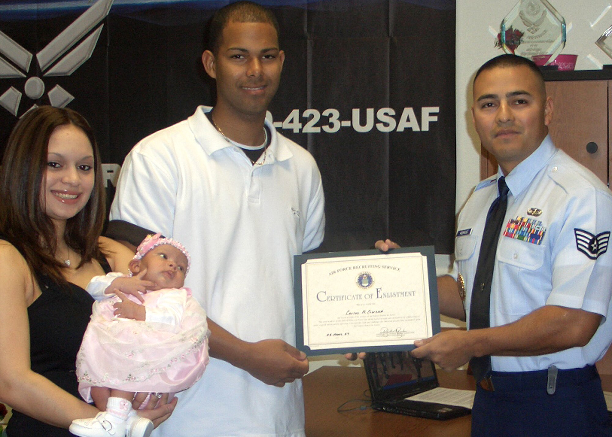 Staff Sgt. Jason Rodriguez, 344th Recruiting Squadron enlisted accessions recruiter in Killeen, Texas, congratulates Carlos Gerena for joining the Air Force by presenting him with a Delayed Entry Program Certificate of Enlistment. Mr. Gerena’s wife, Monica, and daughter share the highlight moment at his side. Air Education and Training Command officials recognized Staff Sgt. Jason Rodriguez as the Air Force’s top recruiter during a ceremony April 13 honoring AETC’s seven Outstanding Airmen of the Year for 2006. (Courtesy photo)