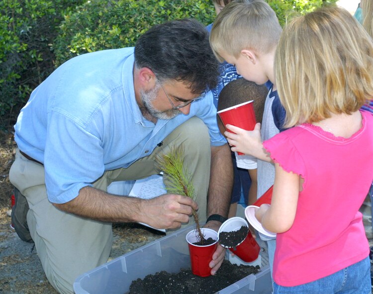 John Crain, 23rd Civil Engineer Squadron base forester, displays the techniques of planting trees to children from the Child Development Center April 12. Members of 23rd CES Environmental Flight also spoke to the children about the positive impacts trees have on the environment. The event coincided with Moody’s celebration of Arbor Day, which recognized the importance of planting trees. (U.S. Air Force photo by Rebecca Evans)