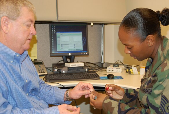 Audiologist Jimmy Pittman shows Tech. Sgt. Nackeesia Holmes a state-of-the-art digital hearing aid in the audiology clinic.  Both are assigned to the 81st Surgical Operations Squadron.  (U.S. Air Force Photo by Steve Pivnick)
