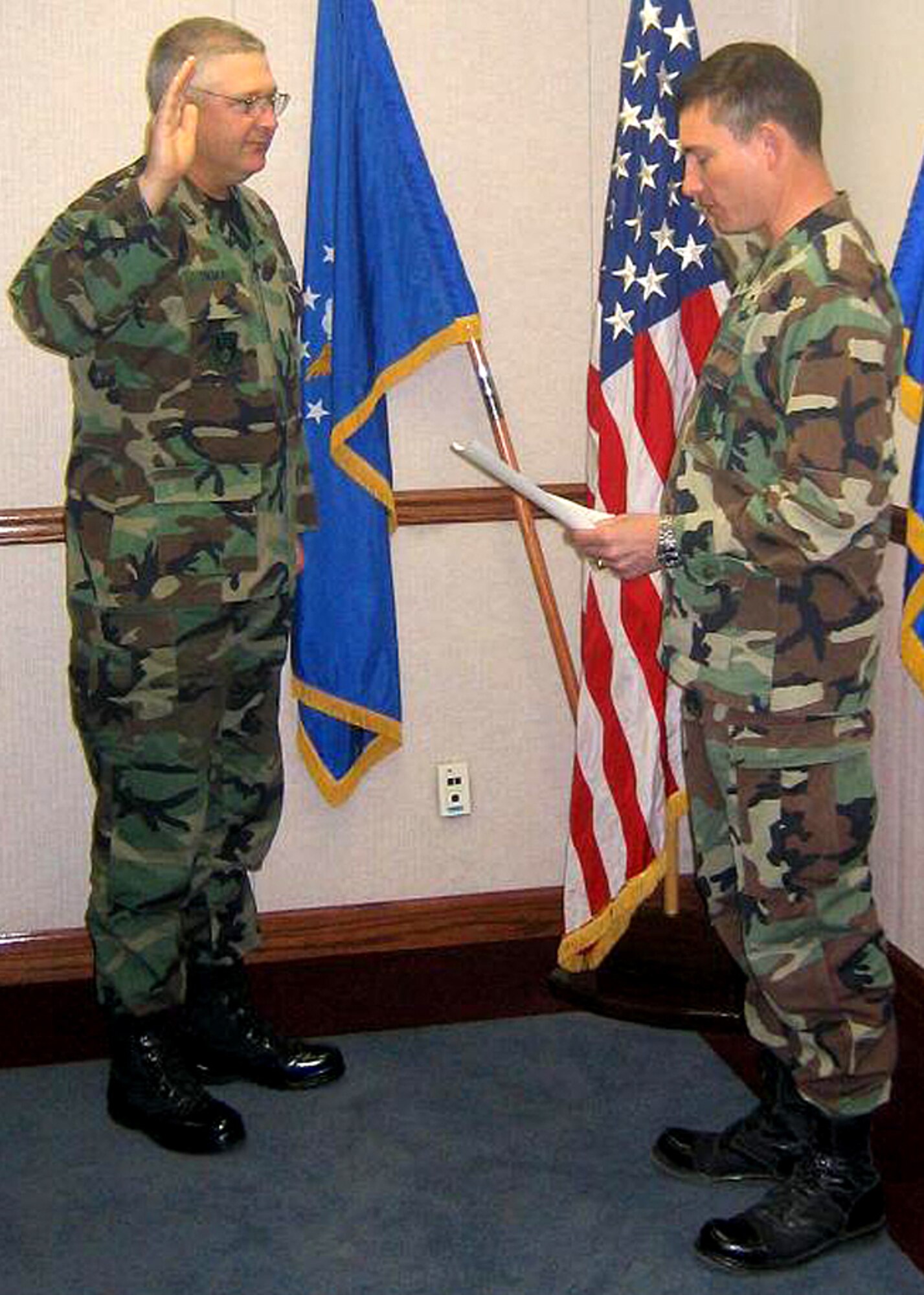 Col. Robert E. Suminsby Jr., 377th Air Base Wing commander, reads the oath of enlistment to Chief Master Sgt. Paul A. Sikora Jr., command chief of the Nuclear Weapons Center here, as he reenlists in the Air Force April 4. (Courtesy photo)