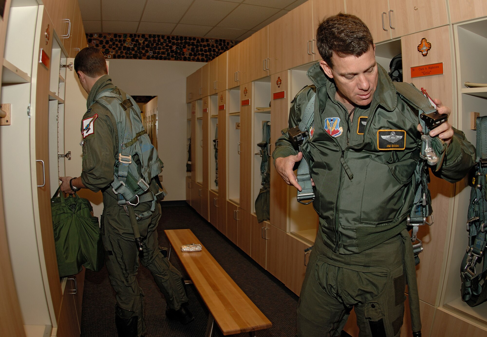 Lt. Col. Jim Dixon and Capt. Kyle Woolf, both pilots for the 150th Fighter Wing here, prepare equipment prior to a sortie. The fighter wing is a New Mexico Air National Guard unit and has been on Kirtland for more than 60 years.  (U.S. Air Force photo by Adam Wooten)