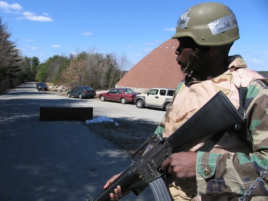 Senior Airman Nicolas Jackson surveys the area while posted at a Camp Patriot entry control point during the recent Hanscom Base Readiness Exercise. The exercise was held in preparation for the upcoming June Operational Readiness  Inspection (U.S. Air Photo by Senior Airman Clint Atkins)