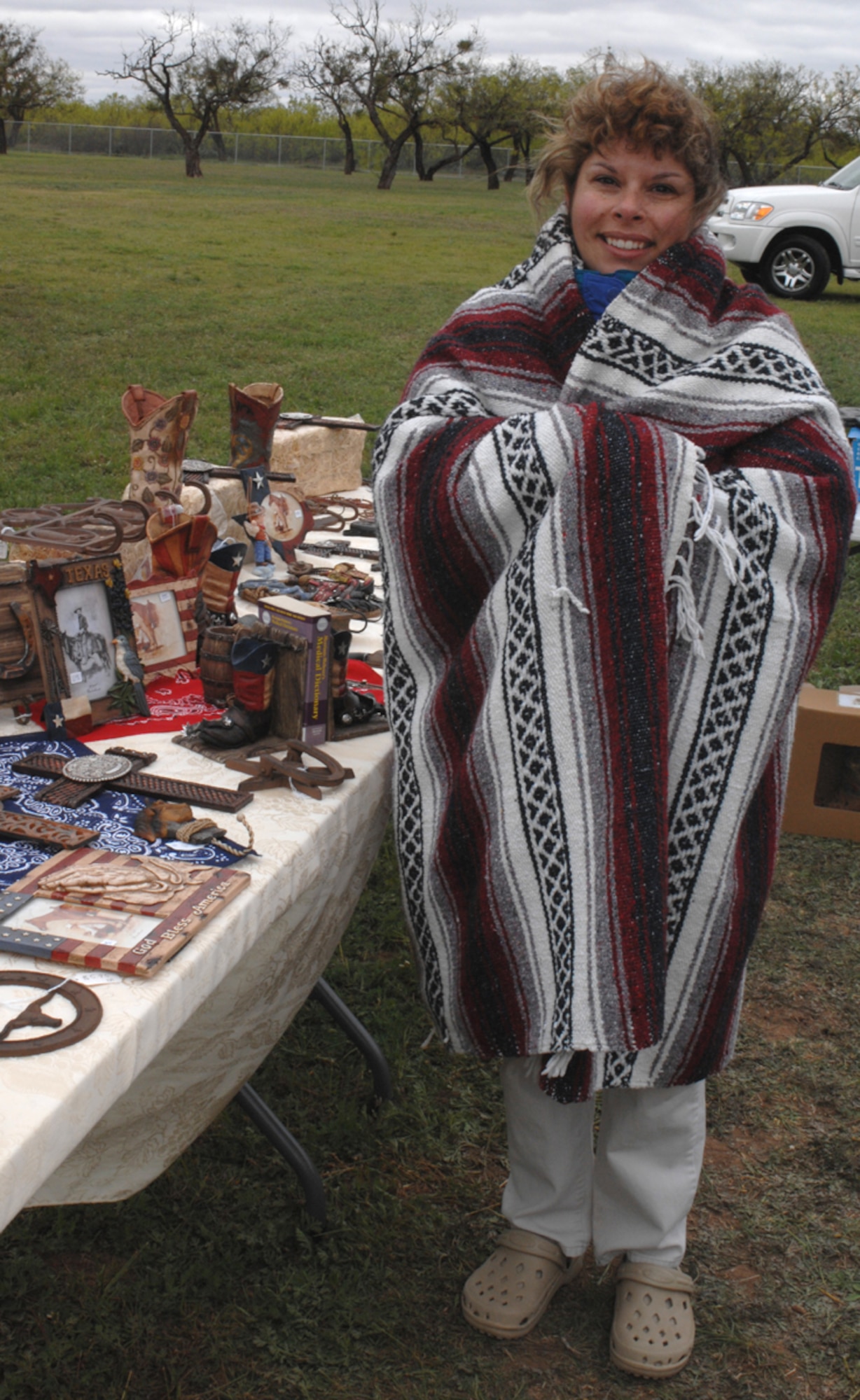 Mrs. Kris Boylan tries to keep warm at Dyess' annual Shoppin' in the Park event at the base picnic grounds April 14. Kris, along with many other civilans and military personnel, brought their goods to the market to sell during the unseasonably cold weather. The event was open to the public. (U.S. Air Force photo by Amn Jennifer Romig)