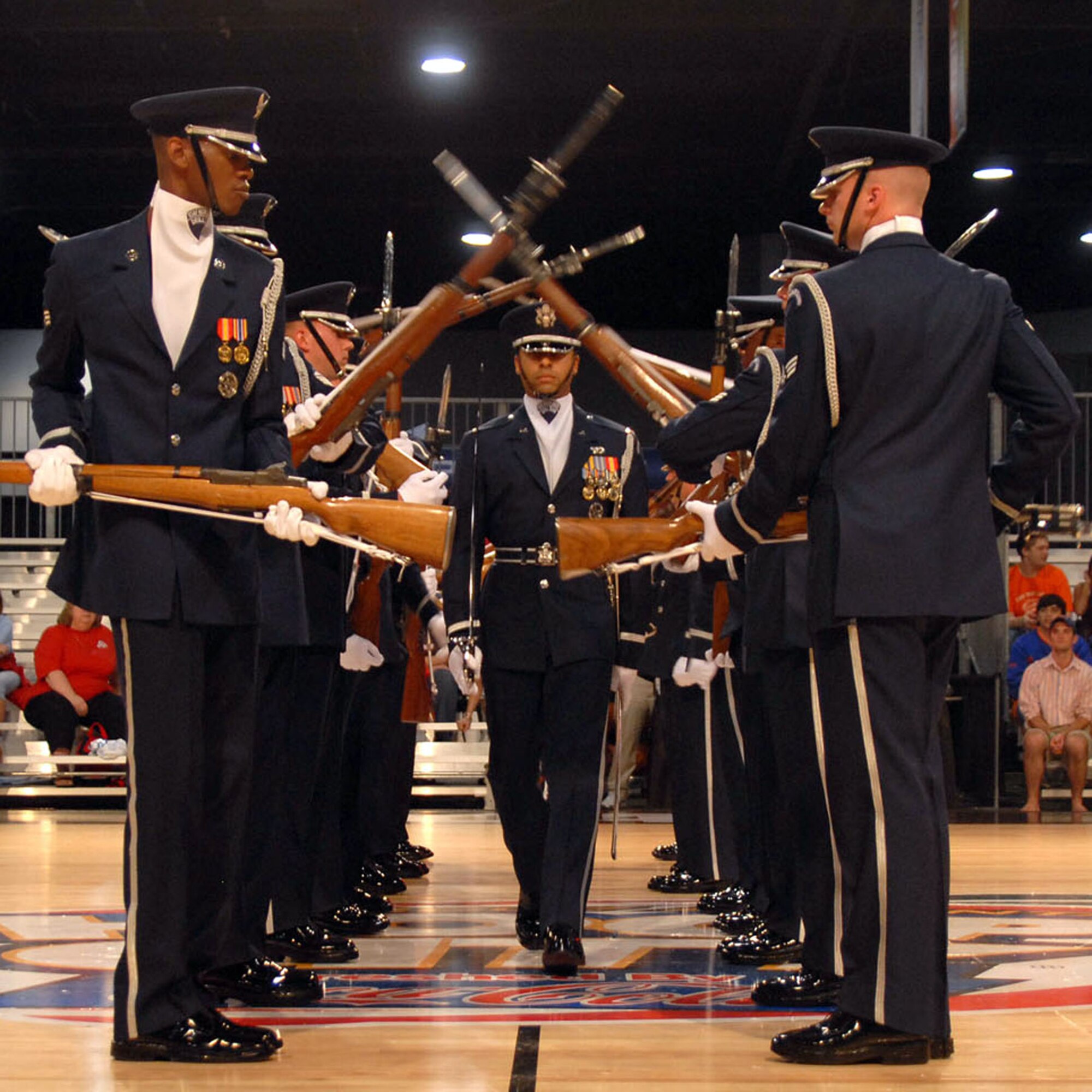 First Lt. Joshua Hawkins walks through the spinning rifles of the Air Force Honor Guard Drill Team during their performance at Hoop City, an event surrounding the NCAA Final Four, April 1 in Atlanta. The drill team recently returned from their latest 11-day tour around the U.S., that included visits to Atlanta; Hill Air Force Base, Utah; and Salt Lake City. (U.S. Air Force photo/Staff Sgt. Madelyn Waychoff)