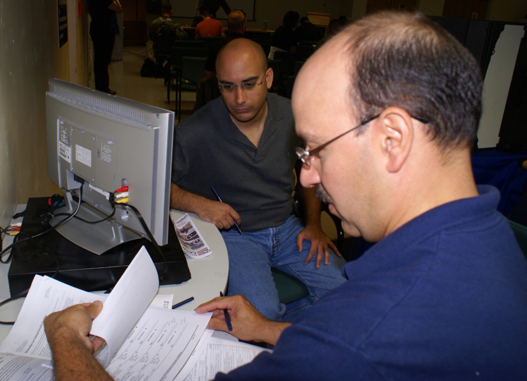 Gregg Perlman, a former Navy and Air Force Reserve munitions specialist, talks with Air Force Reserve recruiter Tech. Sgt. Randy Rodriguez about joining the 482nd Fighter Wing’s Security Forces Squadron during an Individual Ready Reserve muster at Homestead Air Reserve Base April 14.  Mr. Perlman is one of approximately 80 former service members who reported to the base for the annual muster, which gave them the opportunity to receive updated information about the military while fulfilling their obligation to keep their military records updated. (U.S. Air Force photo/Jake Shaw)