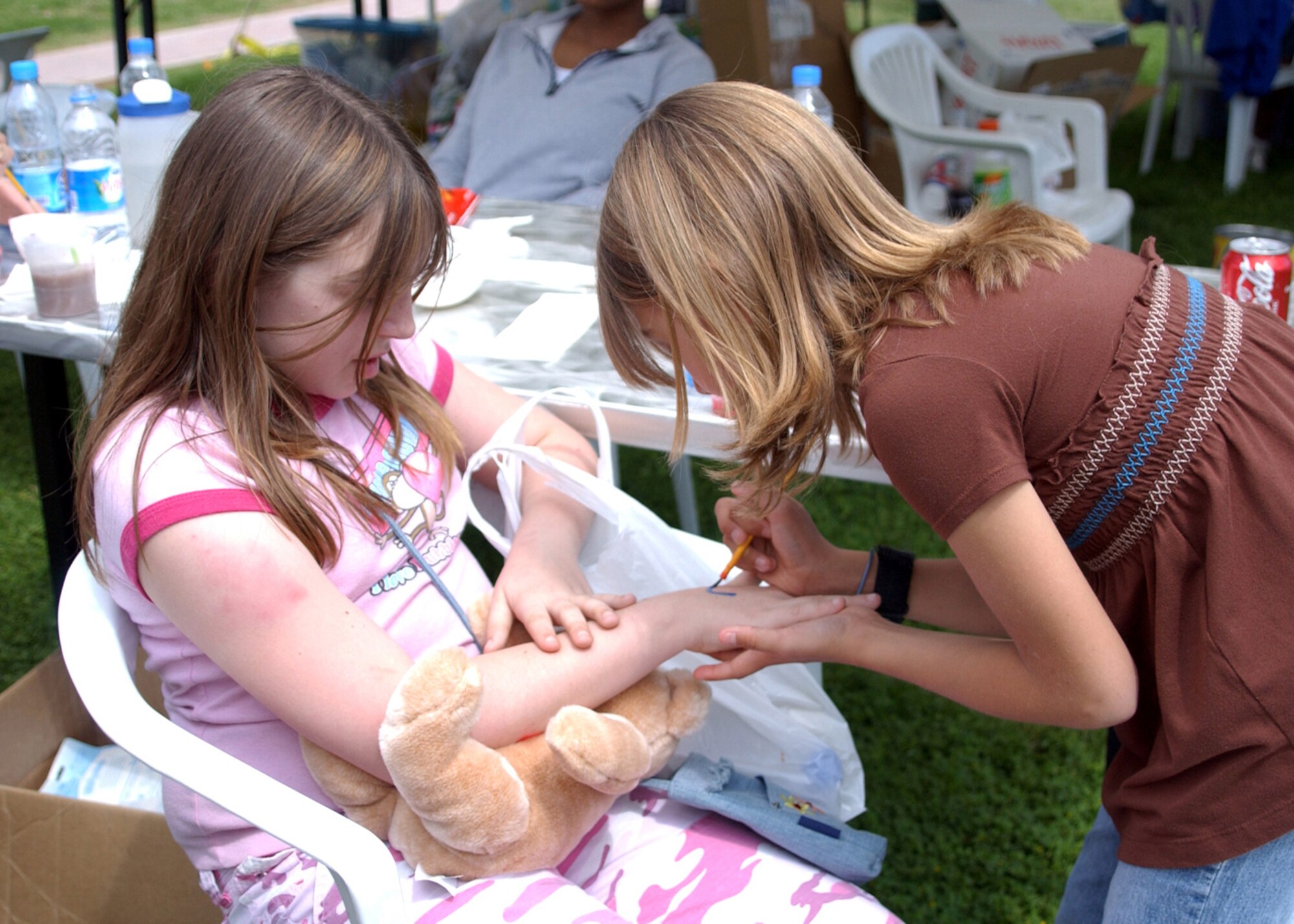 Alese Thuyns paints Elizabeth Niles's hand at the face painting booth during the Spring Fling on April 14.   The Spring Fling was held at Arkadas Park and included pony rides, face painting, food booths, and games.  (U.S. Air Force photo by Airman First Class Tiffany A. Colburn)