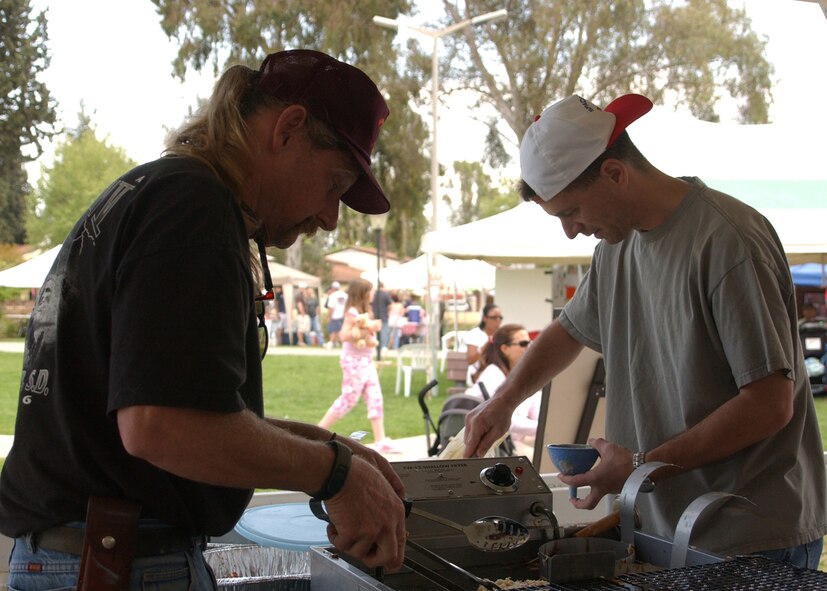 Mike Shrope, left, and Lt. Col. Mike Platt, right, make funnel cakes during the Spring fling on April 14. The Spring Fling was held at Arkadas Park and included pony rides, face painting, food booths, and games.  (U.S. Air Force photo by Airman First Class Tiffany A. Colburn)                               