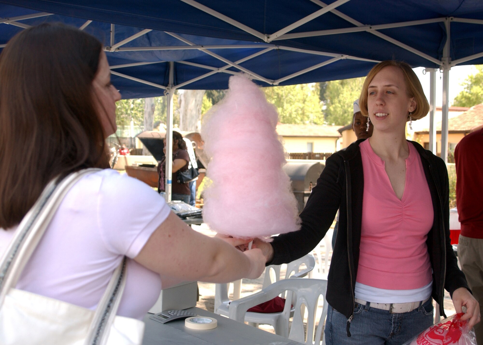 Airman First Class Kelly LeGuillon, 39th Communications Squadron purchases cotten candy from Senior Airman Bethany Cihal, 39th Communications Squadron during the Spring Fling on April 14.  The Spring Fling was held at Arkadas Park and included pony rides, face painting, food booths, and games.  (U.S. Air Force photo by Airman First Class Tiffany A. Colburn)