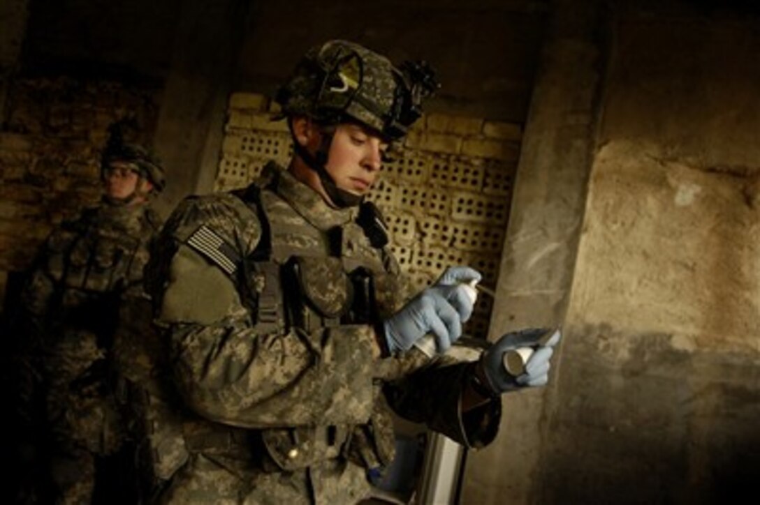 U.S. Army Sgt. Kyle Cox uses the explosive detection kit to determine if an Iraqi man has touched explosives during a joint foot patrol with Iraqi army soldiers from the 1st Platoon, 1st Company, 1st Battalion, 5th Brigade 6th Division in Baghdad, Iraq, April 10, 2007.  Cox is assigned to the 4th Platoon, Alpha Company, 2nd Battalion, 3rd Infantry Regiment, 3rd Stryker Brigade Combat Team, 2nd Infantry Division, Fort Lewis, Wash.  