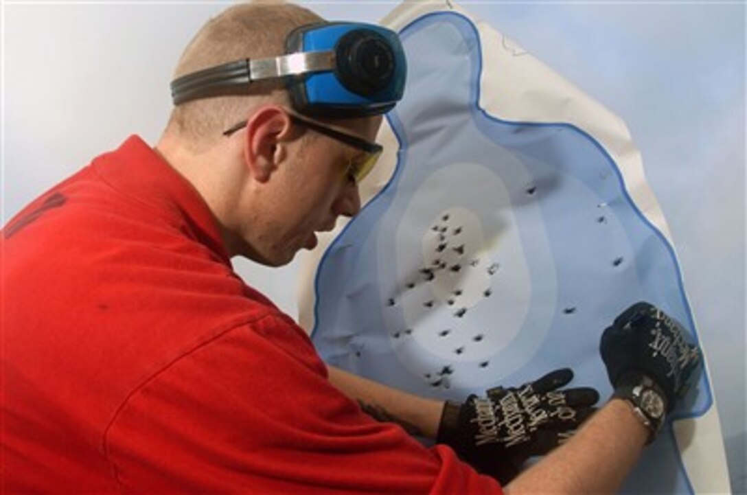 U.S. Navy Petty Officer 2nd Class Robert Baker scores targets during a small-arms exercise on the flight deck of the Nimitz-class aircraft carrier USS John C. Stennis in the Arabian Sea, April 11, 2007. Stennis is on a regularly scheduled deployment in support of maritime security operations 