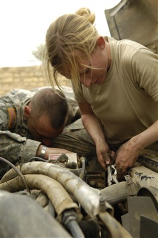 U.S. Army Sgt. Michael Holeman (left) and Spc. Amy Rodgers dive into their work as they perform maintenance on a vehicle at a patrol base in As Sadah, Iraq, on April 6, 2007.  Both soldiers are from Charlie Troop, 5th Squadron, 73rd Cavalry Regiment (Airborne Recon), 3rd Brigade Combat Team, 82nd Airborne Division, deployed from Fort Bragg, N.C.  