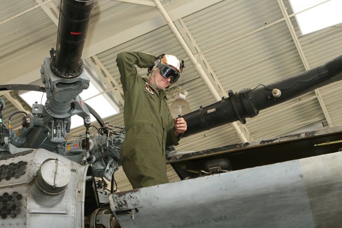 MARINE CORPS AIR STATION MIRAMAR, Calif. ? Sgt. Eric Peacock, a mechanic with Heavy Marine Helicopter Squadron 462, 3rd Marine Aircraft here, demonstrates the proper use of safety equipment required around aircraft while he stands atop a CH-53E Super Stallion. The upcoming VPP CX assessment will look for areas of safety concerns, such as proper regulation implementation, before correcting problem areas on base.