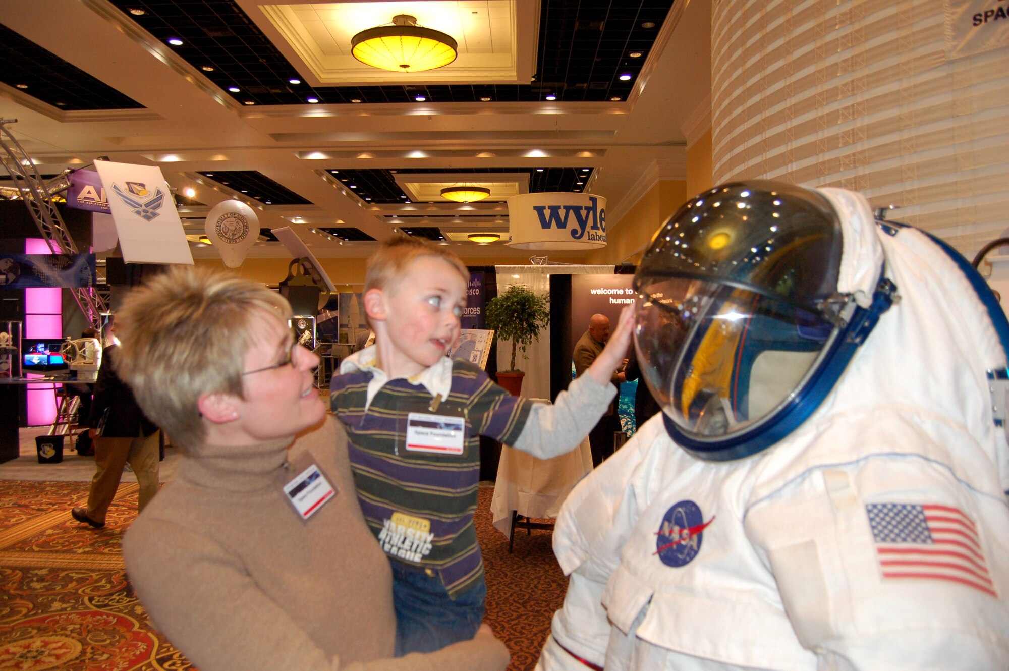 Miranda Sherman lifts up her son Reid, so he can get a closer look at a display, during the 23rd National Space Symposium April 12 at the Broadmoor in Colorado Springs, Colo. In addition to the exhibits, there were numerous guest speakers at the event. (U.S. Air Force photo/Staff Sgt. Jeremy Larlee)

