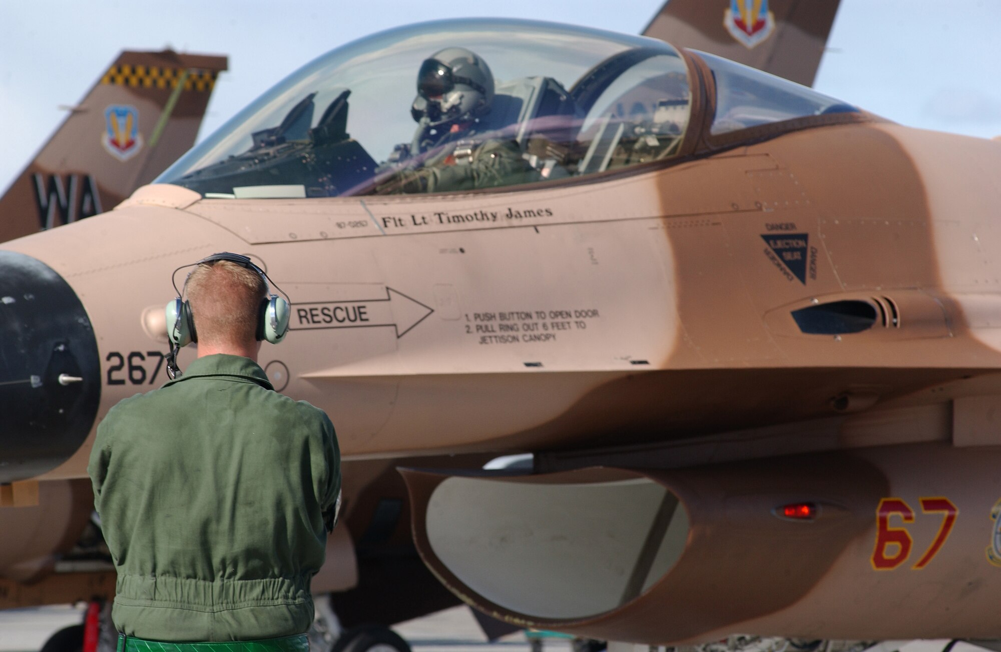EIELSON AIR FORCE BASE, Alaska -- Senior Airman Matthew Gerry, 57th Aircraft Maintenance Squadron, Nellis AFB, Nevada, prepares to marshal an F-16 Fighting Falcon, 64th Aggressor Squadron on April 16 for Red Flag-Alaska 07-1. The Aggressors play a vital role as the "Hostile Forces" for the exercise which helps the units to sharpen their combat skills by flying ten simulated combat sorties in a realistic threat environment.  (U.S. Air Force Photo by Staff Sgt. Tia Schroeder) 