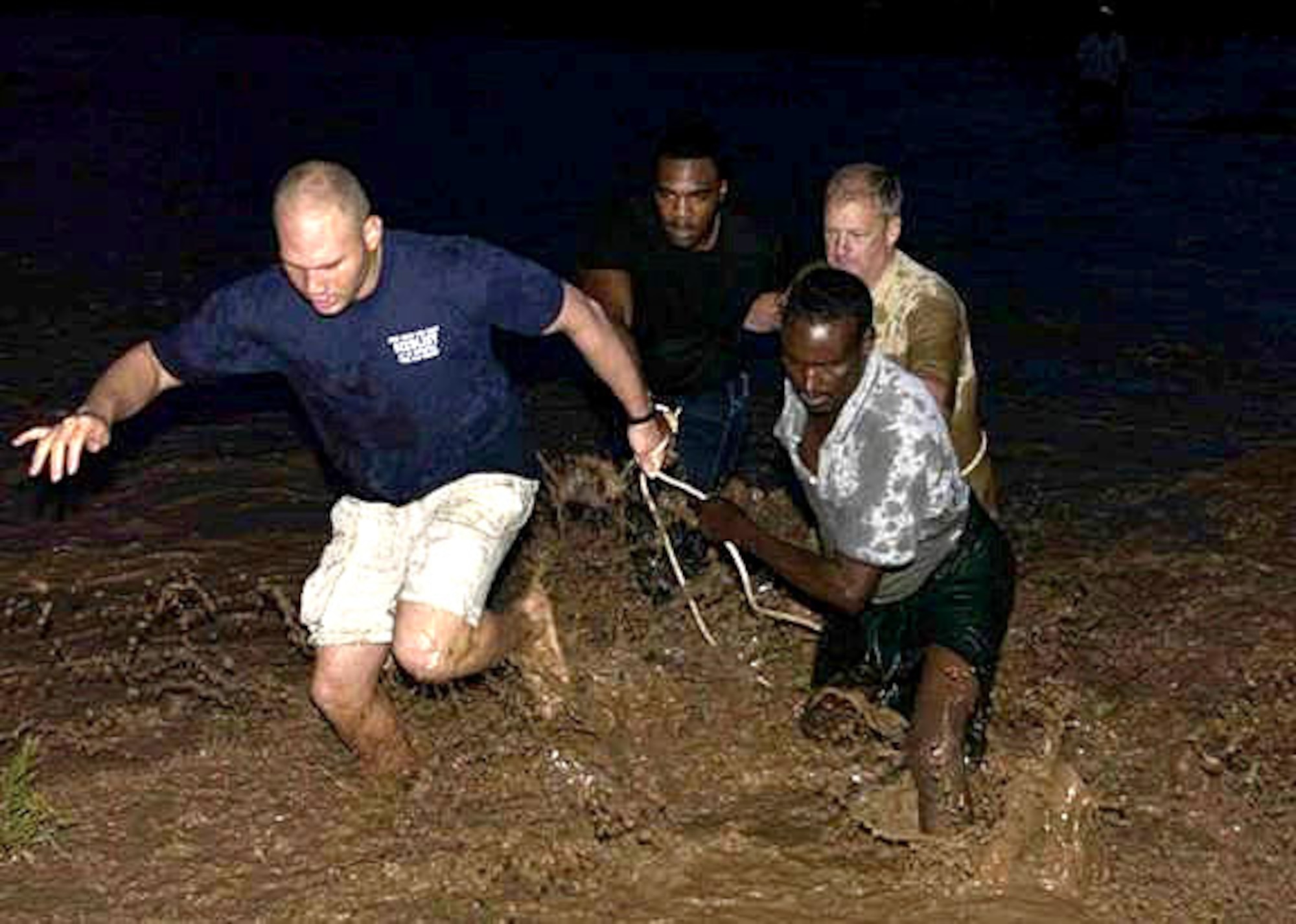 (Clockwise from left) Army Sgt. Rovell Thomas, Senior Airman Travis Manning, Army Col. Vic Adamson, and a Djiboutian volunteer cross a raging river to rescue an injured teenager. Sergeant Thomas is assigned to Delta Company 1st Battalion, 3rd U.S. Infantry Regiment. Airman Manning is part of Combined Joint Task Force--Horn of Africa Combat Camera. Colonel Adamson is assigned to the 350th Civil Affairs Command Functional Specialty. The Combined Joint Task Force - Horn of Africa team was assessing a river crossing site they planned to use the following day as part of a veterinary civic action program when they saw a young man in need of help. (U.S. Air Force photo/Airman 1st Class Bryan Boyette) 