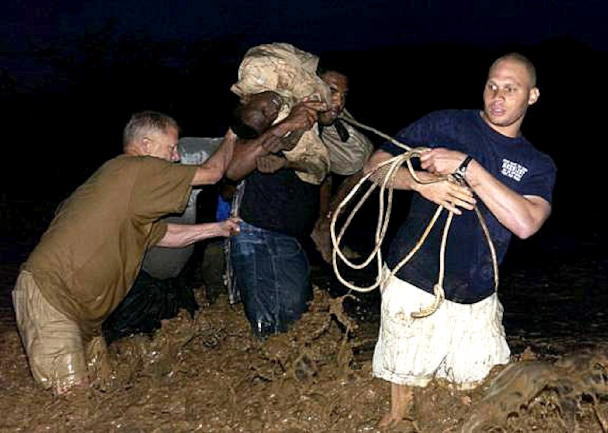 Senior Airman Travis Manning carries an injured youth on his shoulders with the assistance of Army Col. Vic Adamson (left) and Army Sgt. Rovell Thomas (right). Airman Manning is part of Combined Joint Task Force--Horn of Africa Combat Camera. Colonel Adamson is assigned to the 350th Civil Affairs Command Functional Specialty. Sergeant Thomas is assigned to Delta Company 1st Battalion, 3rd U.S. Infantry Regiment. The Combined Joint Task Force - Horn of Africa team was assessing a river crossing site they planned to use the following day as part of a veterinary civic action program when they saw a young man in need of help. (U.S. Air Force photo/Airman 1st Class Bryan Boyette) 
