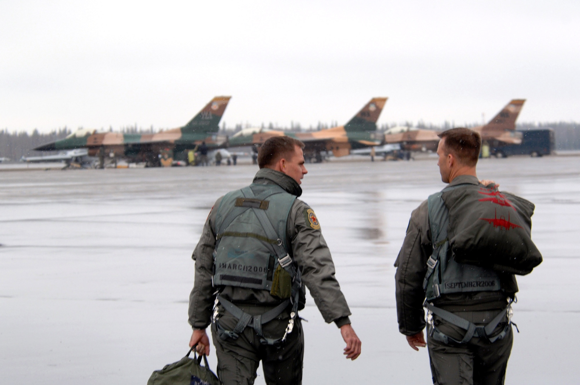 Two F-16 Fighting Falcon pilots walk toward their jets prior to a mission April 12 during Red Flag-Alaska 07-1 at Eielson AFB, Alaska. Red Flag-Alaska is a Pacific Air Forces-directed field training exercise for U.S. forces flown under simulated air combat conditions. It is conducted on the Pacific Alaskan Range Complex with air operations flown out of Eielson and Elmendorf Air Force Bases. The pilots are from the 64th Aggressor Squadron at Nellis Air Force Base, Nev. (U.S. Air Force photo/Staff Sgt. Joshua Strang)