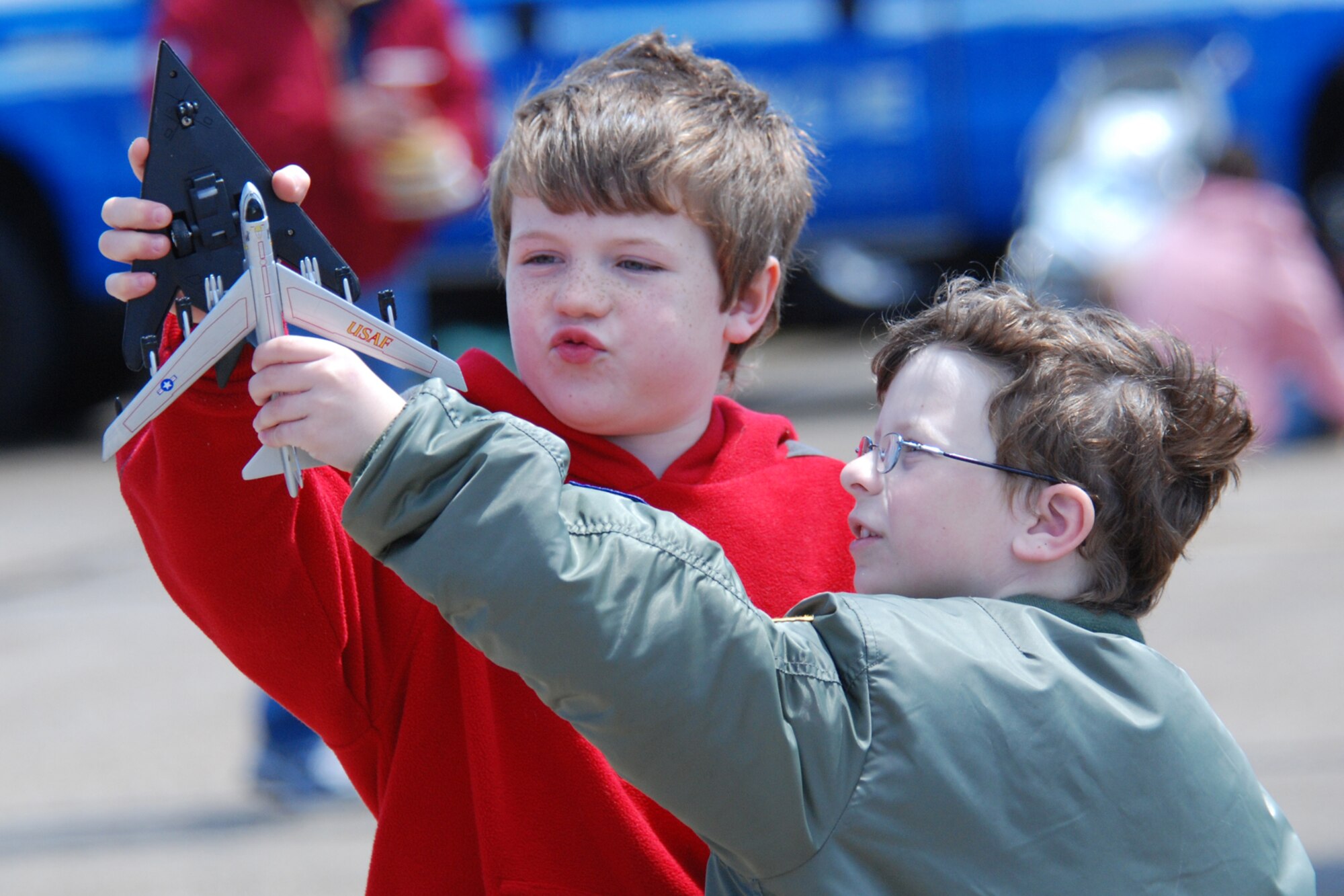 EGLIN AIR FORCE BASE, Fla. -- Luke McCaleb, 8, and Brent Wilson, 7, take their toy F-117 Stealth fighter and B-52 bomber into vertical climbs during the 2007 Eglin Air Show April 15. The boys and their fathers drove more than five hours to see the show. The first day of the air show was cancelled due to severe weather coming into the area. Although the second day was cold and windy, more than 42,000 braved the elements to watch the aerial acrobatics in the skies over Eglin. (U.S. Air Force photo by Staff Sgt. Mike Meares)