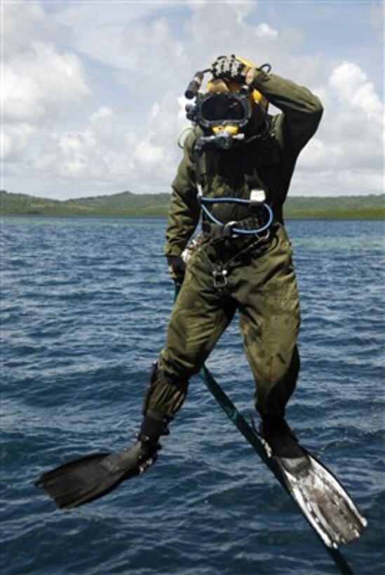 U.S. Navy Diver Curtis Wiley jumps off a dive station near the coast of Aimeliik, Republic of Palau, to do an excavation dive on Feb. 26, 2007.  Petty Officer 3rd Class
Wiley is temporarily assigned to the Joint POW/MIA Accounting Command to aid in the recovery of eight members of a U.S. Army Air Corps crew lost when their aircraft was shot down during World War II.  The Joint POW/MIA Accounting Commandís mission is to achieve the fullest possible accounting of all Americans missing as a result of the nation's past conflicts.  Wiley is deployed from the Mobile Diving and Salvage Unit One, Detachment 7, Pearl Harbor, Hawaii.  