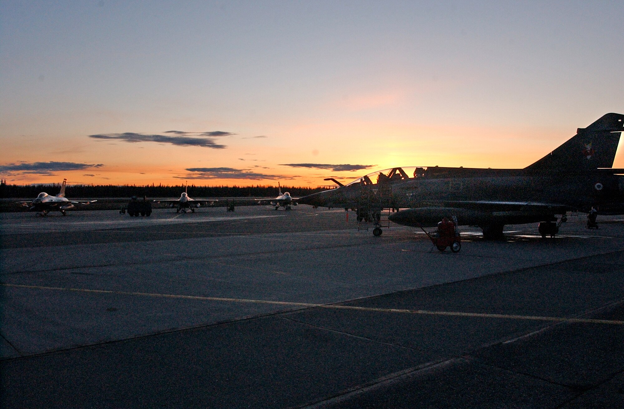 EIELSON AIR FORCE BASE, Alaska--The sun sets on a group of F-16 Fighting Falcons from the 61st Fighter Squadron at Luke AFB, and a French Mirage 2000 sit on the flight line April 16 during Red Flag-Alaska 07-1.  More than 1,300 military members from the United States, France and Australia have gathered in the Last Frontier to participate in Red Flag-Alaska 07-1 scheduled from April 5 to 21. (U.S. Air Force photo by Senior Airman Justin Weaver).
