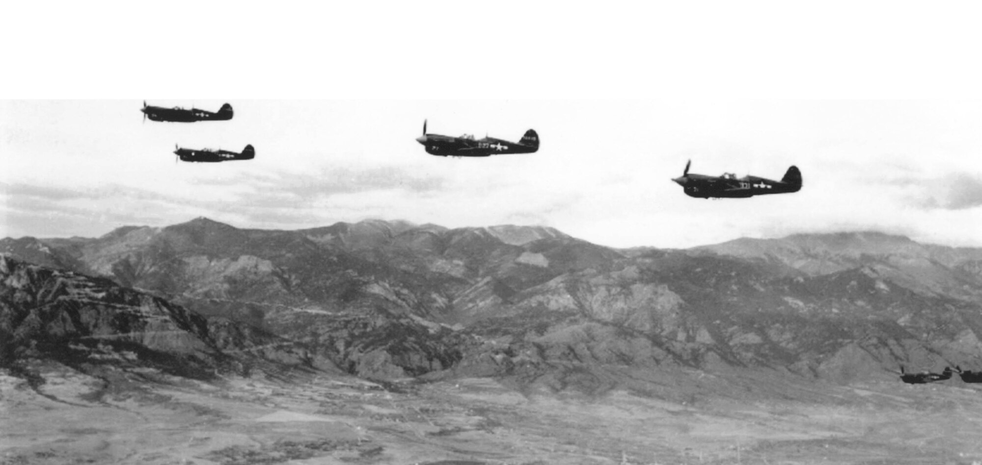 A formation of P-40 “Warhawk” fighters passes along the Front Range in 1944.  The Peterson Museum has a replica of this aircraft type on display at the corner of Peterson Boulevard and Ent Avenue. (U.S. Air Force photo)