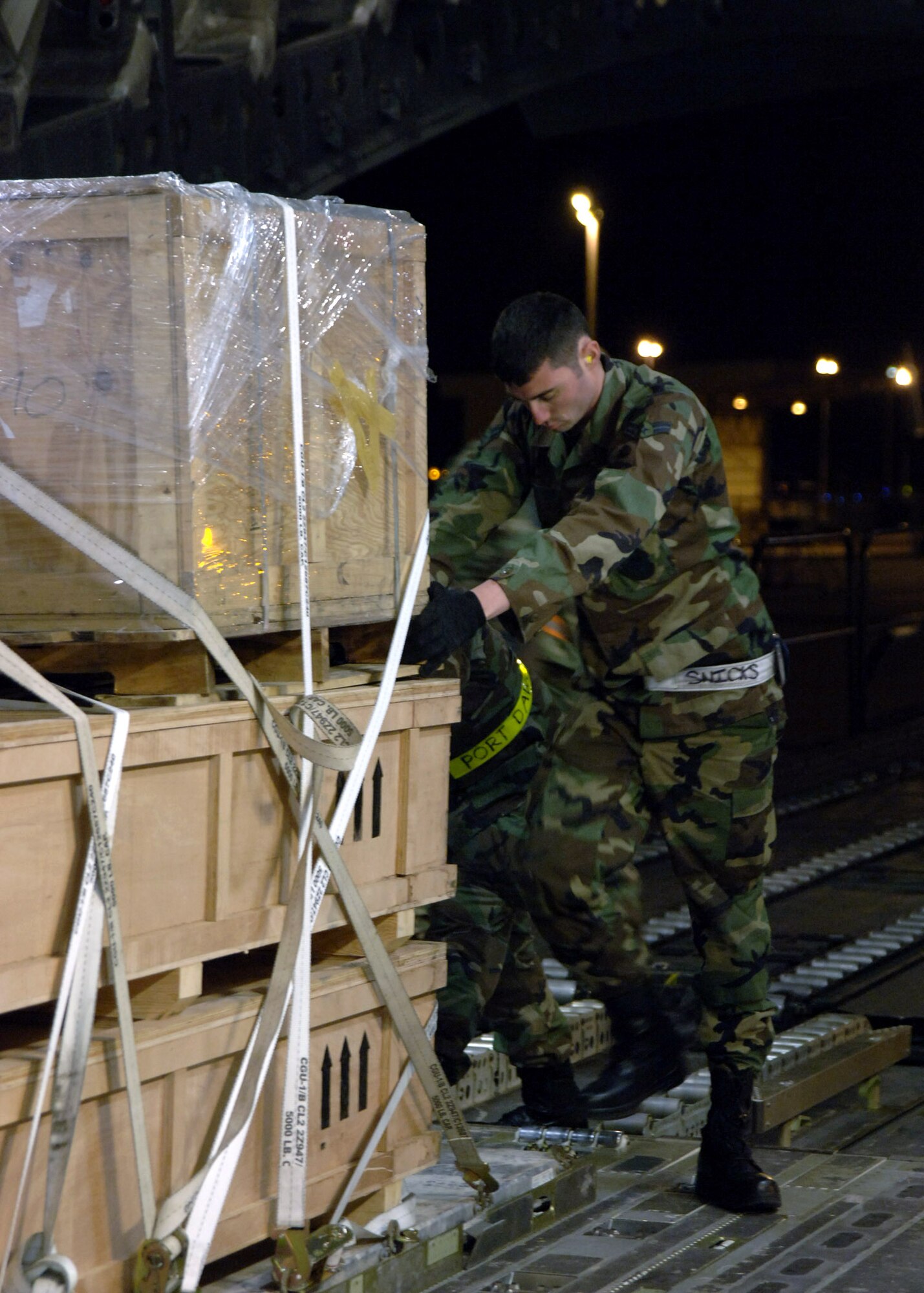 Airman 1st Class Brian Pryor secures Turkish equipment onto a C-17 Globemaster III April 16 at Incirlik Air Base, Turkey. The equipment is being transported to Kabul AB, Afghanistan. Airman Pryor is a 728th Air Mobility Squadron load team member. (U.S. Air Force photo)