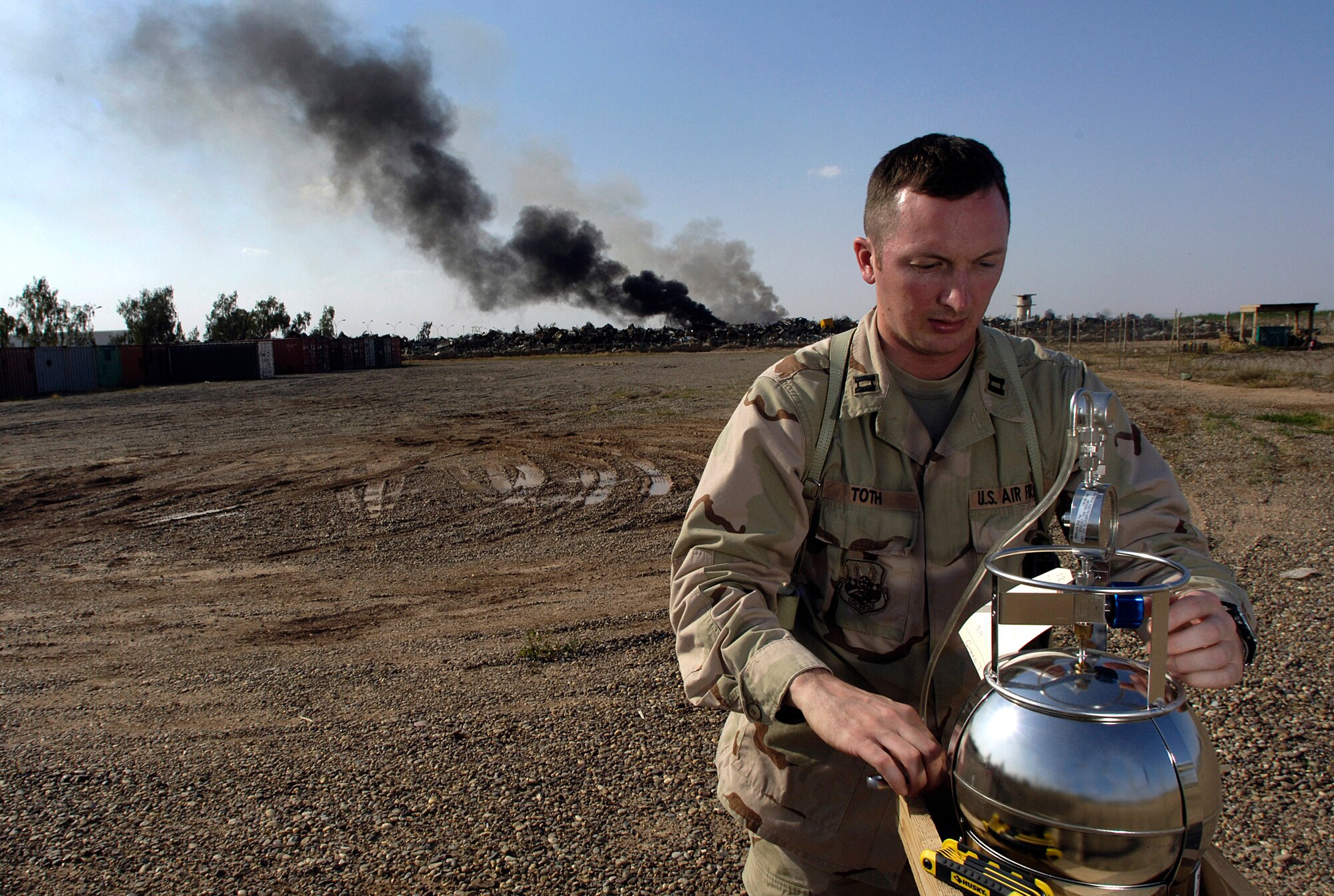 Capt. Charles Toth checks a monitoring device April 13 at Balad Air Base, Iraq, for common pesticides and other environmental hazardous chemicals in the air.  Captain Toth is the bioenvironmental engineer flight commander. Bioenvironmental engineers perform environmental, occupational and radiological surveillance in order to protect and maintain a healthy work force, and they serve as mission enhancers during emergency management response operations. (U.S. Air Force photo/Airman 1st Class Nathan Doza) 