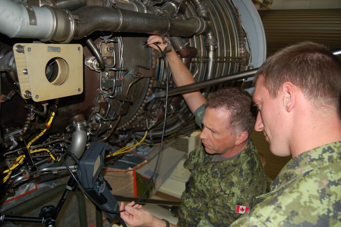 Master Cpl. Tim Parker and Cpl. Marc Bruyere, Royal Canadian Air Force 429th Squadron aviation technicians, learn how to boroscope a C-17 engine. (U.S. Air Force photo/Tech. Sgt. Christopher Prestero)